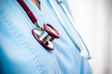 close up of doctor’s blue uniform and stethoscope