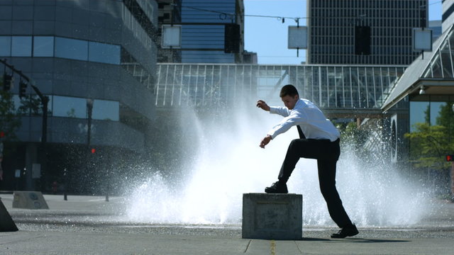 Business man does flip in front of city fountain
