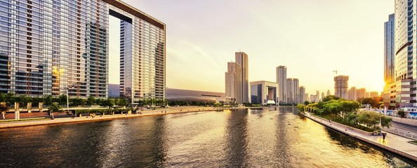 modern skyscrapers and skyline during sunset at riverbank