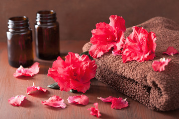spa bathroom with azalea flowers essential oil on dark rustic ba