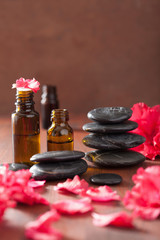 Fototapeta na wymiar essential oil azalea flowers black massage stones