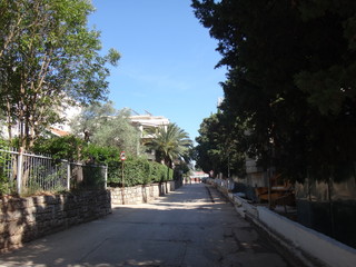 Неширокая улица в небольшой южном городке, окруженная зеленью