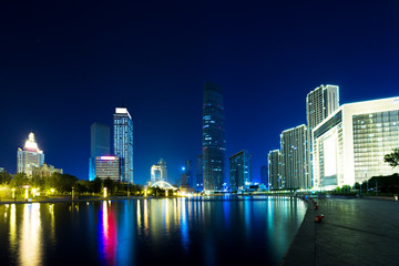 Fototapeta na wymiar Illumintaed modern skyscrapers and skyline at riverbank