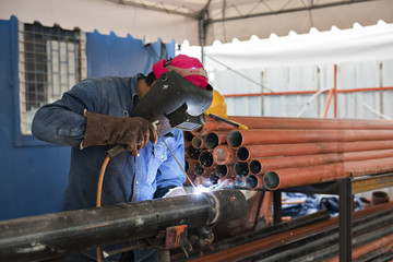 Worker welding the steel part by manual