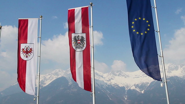 Tyrol, Austrian, EU flags waving, grand snowy Alps on background