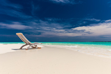 Fototapeta na wymiar Beach view of amazing water and empty chair on sand for relaxing