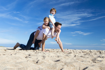 Fototapeta premium Family on the Beach Flying a Kite