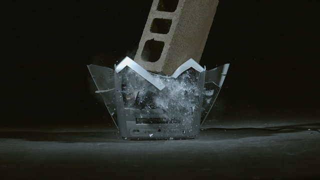 Concrete block is dropped on television in slow motion