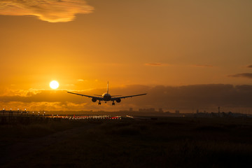 Fototapeta na wymiar Airplane almost landed during a nice sunrise.