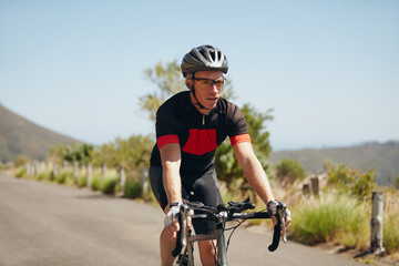 Young man riding bicycle on open road