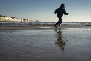 Silhouette d'enfant courant sur la plage
