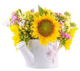 Yellow sunflowers and colored wild flowers in a white sprinkler