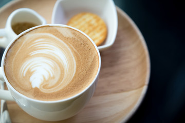 Hot latte art coffee on table