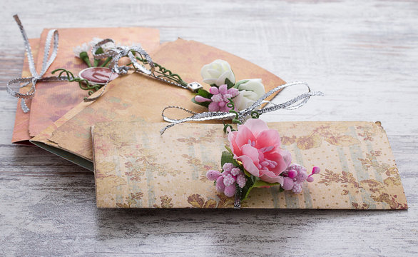 Handmade wedding invitations made of paper pver wooden vintage background