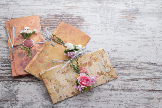 Handmade wedding invitations made of paper pver wooden vintage background