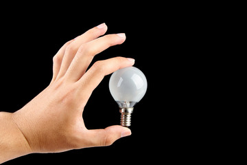 Holding light bulb with black background