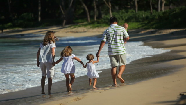 Family walking on beach, Hawaii