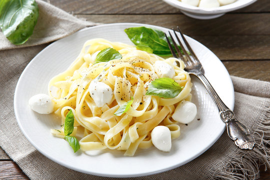 Pasta with mozzarella and basil on a plate