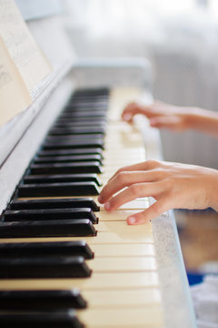 hands of a young girl playing the piano