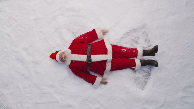 High angle shot of Santa Claus making a snow angel