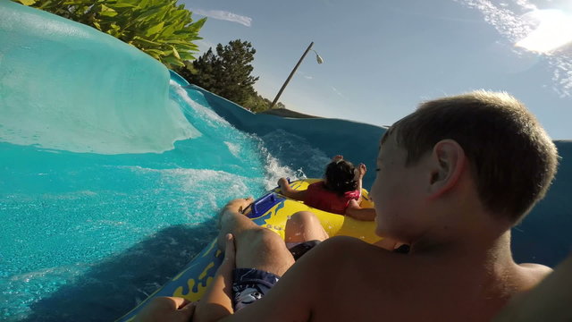 Kids going down a waterslide at waterpark, POV video