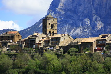 Vista de monta&ntilde;a y &aacute;rboles, Pirineos, cielo azul, nubes y d&iacute;a soleado. Vistas del pueblo desde el embalse, torre de iglesia, casas cerca del R&iacute;o Cinca, &aacute;rboles inundados