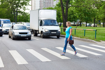 Woman crossing the street at pedestrian crossing