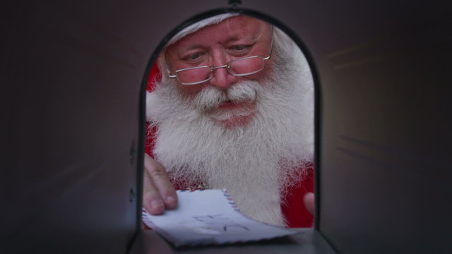 Santa Claus opens mailbox and gets letter