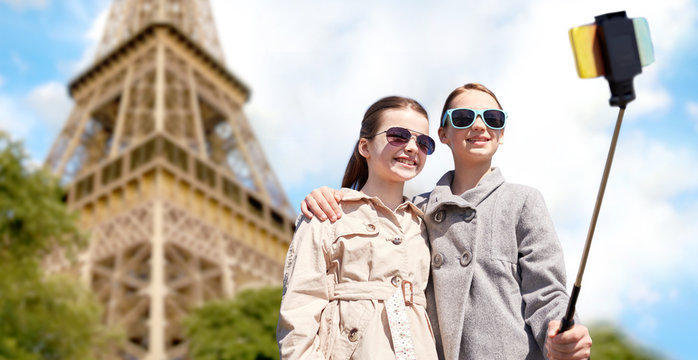 girls with smartphone selfie stick at eiffel tower
