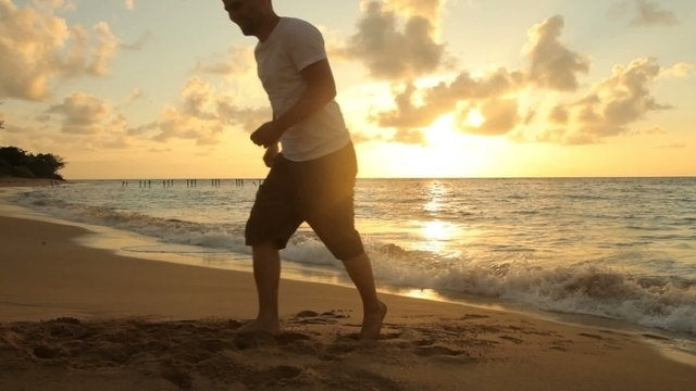 Father and daughter play at beach, sunset