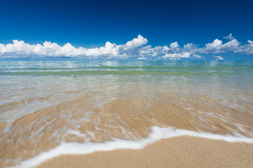 sea waves lash line impact on the sand beach under blue sky