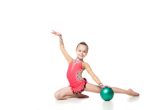 pretty little girl doing gymnastics with a ball over white