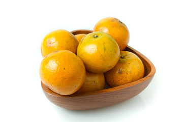 oranges in wooden bowl on isolated white