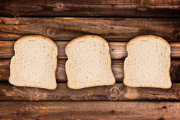Three slices of bread, on wood planks background