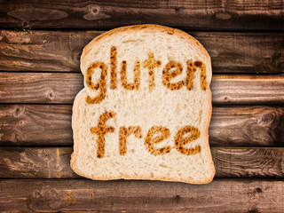 Text  gluten free toasted on a slice of bread, isolated on wood background