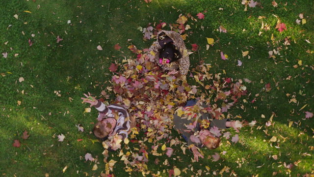 Family playing with autumn leaves