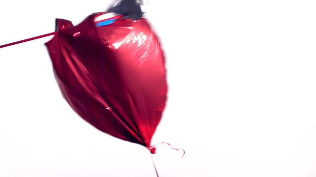 Arrow shot through a heart shaped Valentine's Day balloon