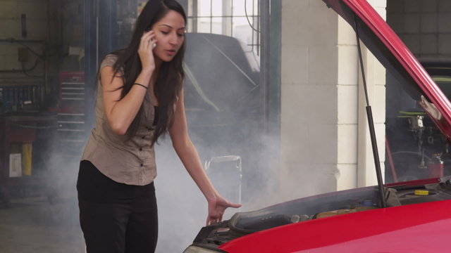 Woman having car trouble and talking on cell phone