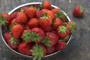 Fresh strawberries in a bowl on wooden table