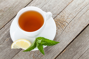 Green tea with lemon and mint on wooden table