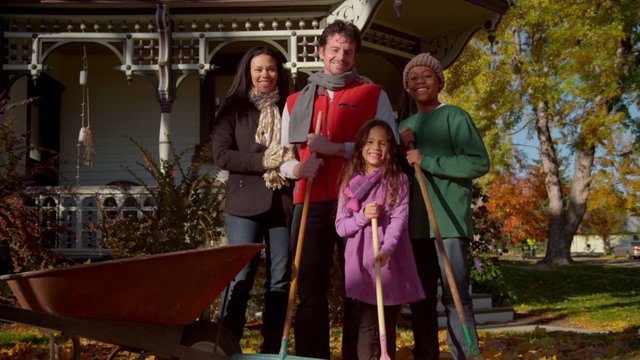 Happy mixed race family playing in autumn leaves