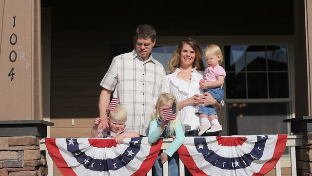 Family On Porch With American Flags