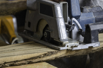 Male carpenter is cutting wood.