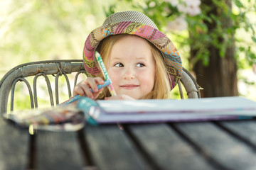 Beautiful blond girl in the garden at sunny summer day