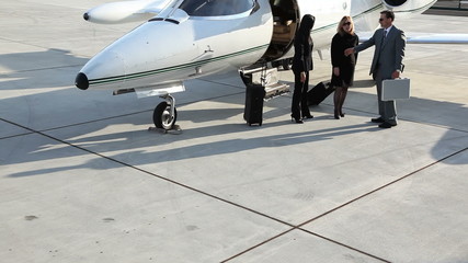 Businesspeople shaking hands by jet - Powered by Adobe