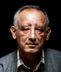 Portrait of a senior man on black background, Front view