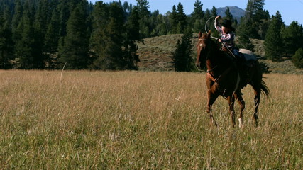 Young boy riding horse with lasso, slow motion