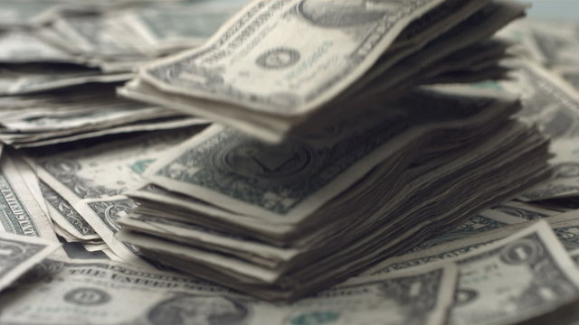 Stack of dollar bills falling, slow motion