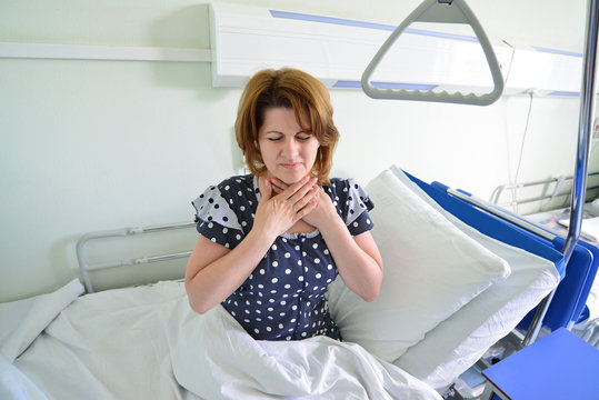 Female patient with angina on  bed in hospital ward