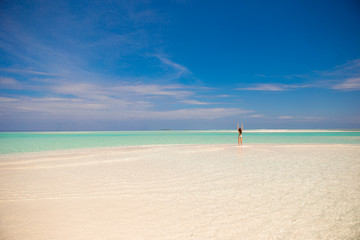 Young happy woman on white sandy beach